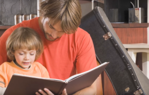 parent reading to child with guitar case in background